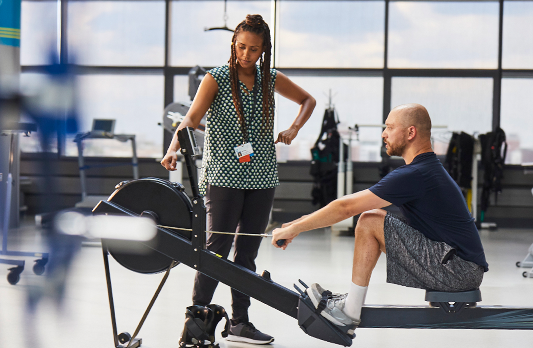 female provider with patient at rowing machine